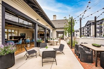 a patio with tables and chairs and a building in the background